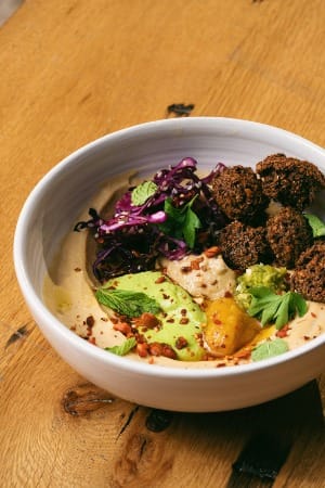 a white bowl filled with food on top of a wooden table